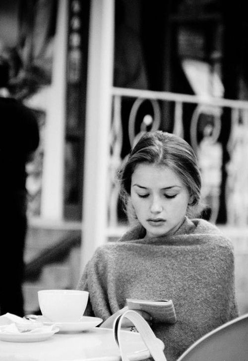 Девушка читает любовный роман и пьет кофе