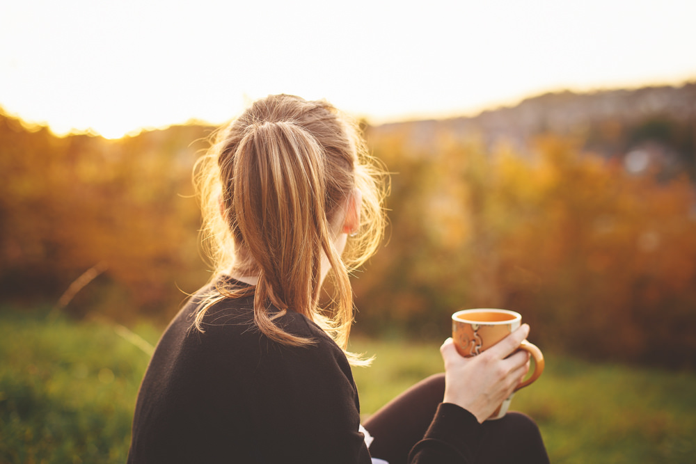 Девушка пьет кофе на природе