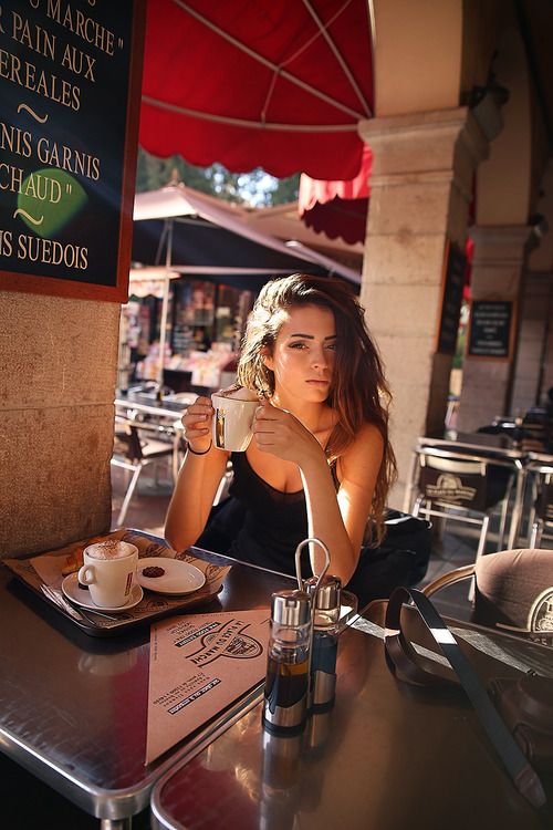 Красивая девушка в кафе пьет кофе