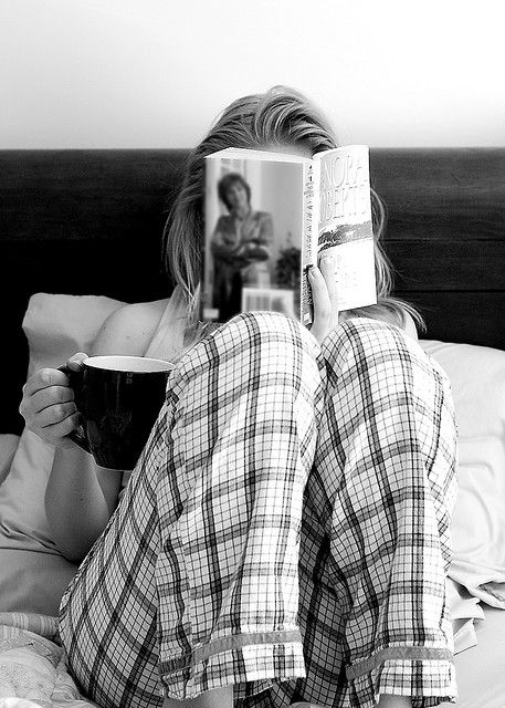 Девушка пьет кофе и читает книгу